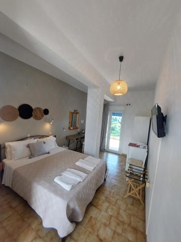 a bedroom with a large bed and a television at Mirsini Rooms in Votsi