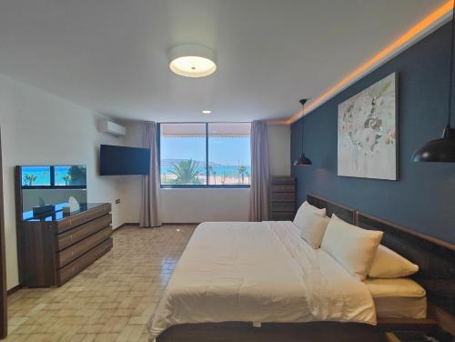 a bedroom with a large white bed and a desk at Villa Mirasol Hotel in Tangier