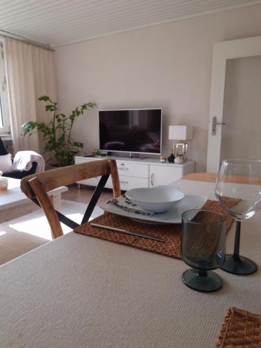 a living room with a table with a wine glass at Ferien am See in Möhnesee
