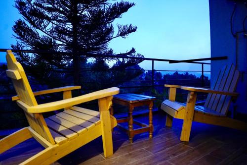 two chairs and a table on a balcony with a christmas tree at Republika Central Hotel & Resort in Abbottabad