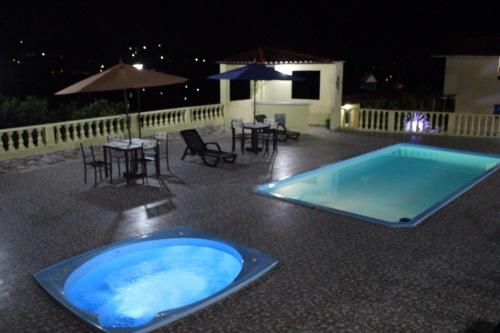 una gran bañera de hidromasaje azul en un patio por la noche en Casa Campestre Villa Esperanza, en Silvania