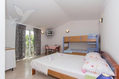 a bedroom with a bed and a table and chairs at Villa Nada - STUDIO 11 in Duće