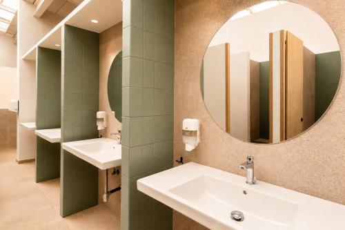 a bathroom with two sinks and a mirror at Kampaoh Cambrils in Cambrils