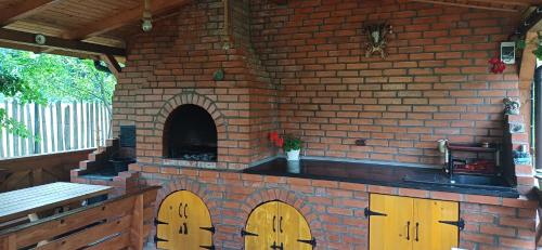 an outdoor kitchen with a brick oven with wooden doors at Casuta lui Andrei in Brezoi