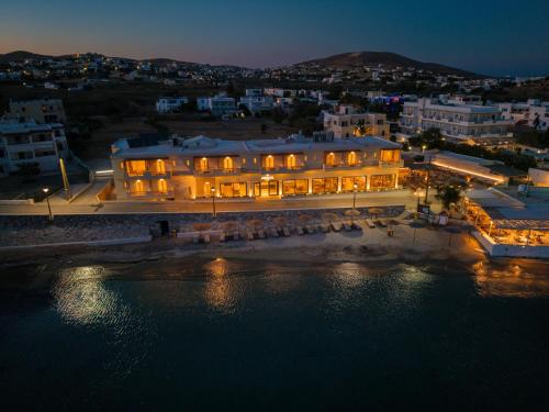 a large building on the shore of the water at night at Armia Experience Hotel in Vári