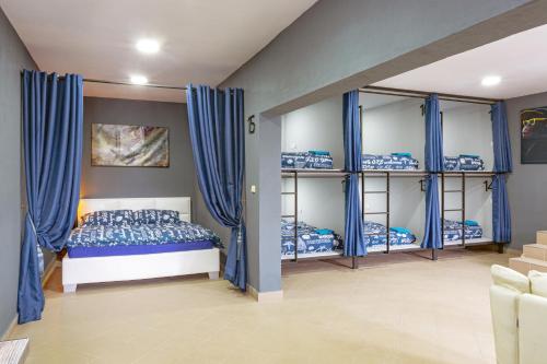 a bedroom with blue bunk beds and blue curtains at Hostel IRON CUBE in Stružná