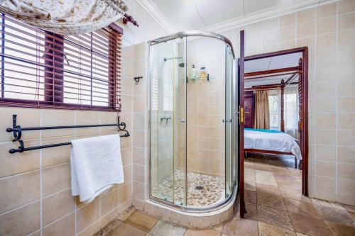 a shower with a glass door in a bathroom at 42onKing in Centurion