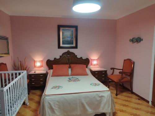 a bedroom with a bed and two tables and a crib at Casa Da Vieira in Ourense