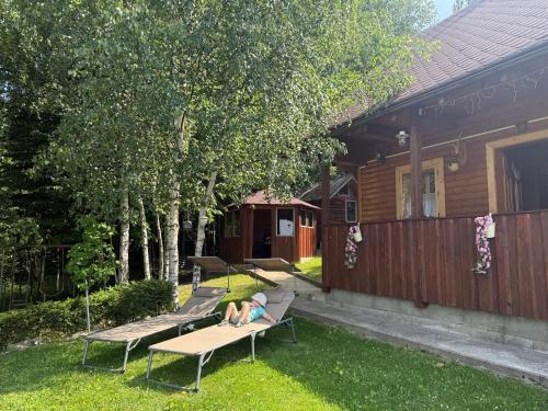 a child laying on a bench in a backyard at Drevenica U Bučkov in Lutiše