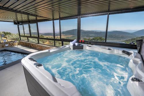 a jacuzzi tub in a building with a view at כתר הגליל - ווילה יוקרתית עם 4 סוויטות ובריכה מפנקת in ‘Ein el Asad