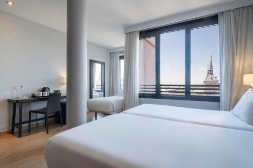 ein Schlafzimmer mit Bett, Schreibtisch und Fenster in der Unterkunft Exe Moncloa in Madrid