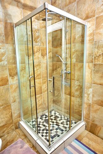 a shower with a glass enclosure in a bathroom at Potato Suites n Spa in Gaborone
