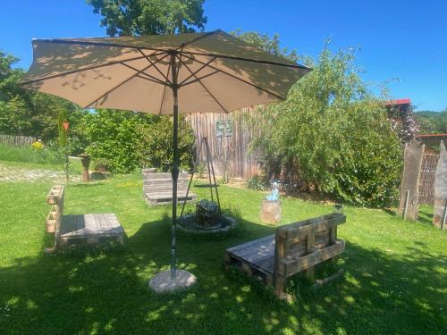 an umbrella and a bench in a yard at Tiny House 47 in Egloffstein
