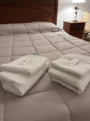 a bed with white towels on top of it at Casa Rivadavia in Rafaela