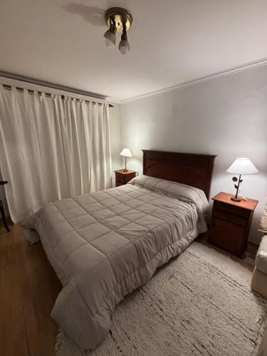 a bedroom with a large bed and two night stands at Casa Rivadavia in Rafaela
