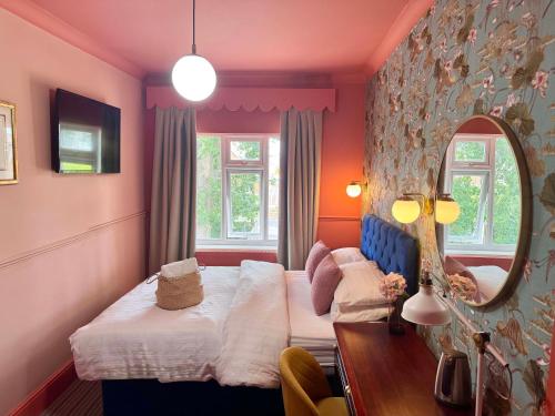 ein Schlafzimmer mit zwei Betten und einem Spiegel in der Unterkunft The Emsworth Hotel in Emsworth