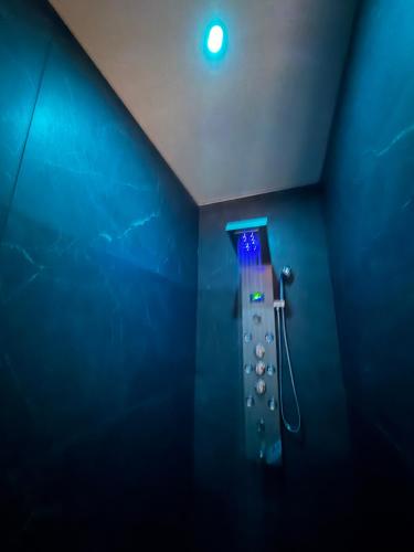 Eine Dusche in einem blauen Raum mit blauer Wand in der Unterkunft Love room l'Evasion in Esprels
