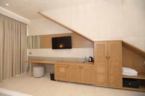 a room with a desk with a tv on the wall at Elite Bay Hotel Lalez Durres in Lalëz