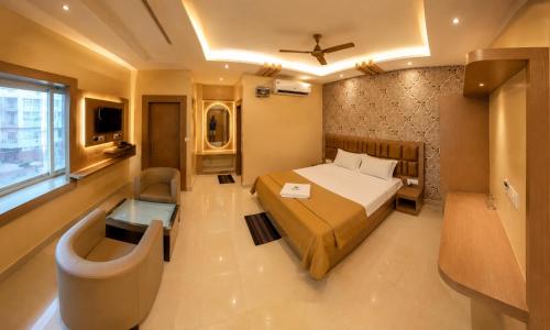 a bedroom with a bed and a chair and a window at Hotel Baikuntha International Puri Near Sea Beach With Parking AC Or Non AC Both Room in Puri