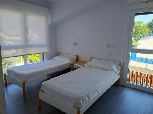 two beds in a room with a window at Hamabi in Hendaye
