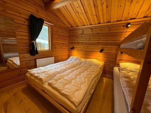 a bedroom with a bed in a wooden room at Charmig timmerstuga i Vemdalen in Vemhån