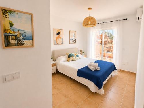 a bedroom with a bed with a blue blanket at Mirador de las Gaviotas in Mojácar