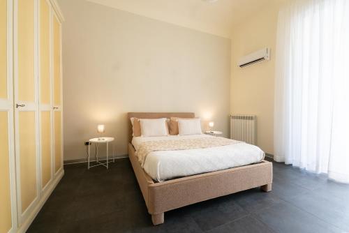 a bedroom with a bed with white sheets and pillows at Dimora Altea in Taranto