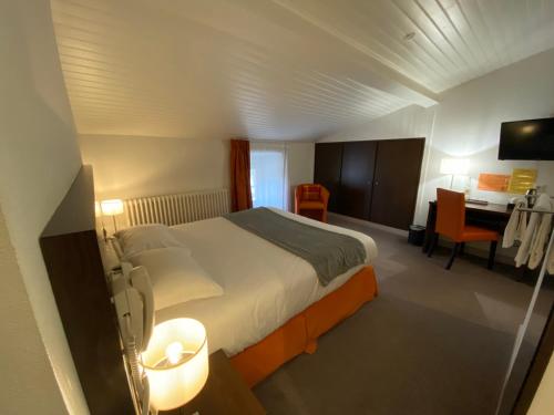 a hotel room with a bed and a desk at Hotel de Montaulbain in Verdun-sur-Meuse