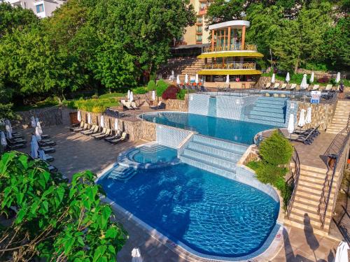 an overhead view of a swimming pool with chairs and a building at Hotel Sunrise Golden Sands in Golden Sands
