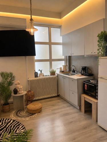 a kitchen with white cabinets and a large window at Skyline apartment Ioannina in Ioannina