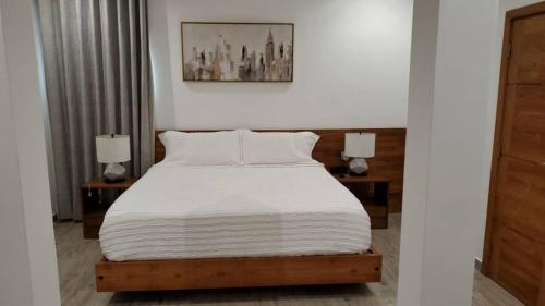 a bedroom with a white bed with two lamps at Habia Residence in Grand-Popo