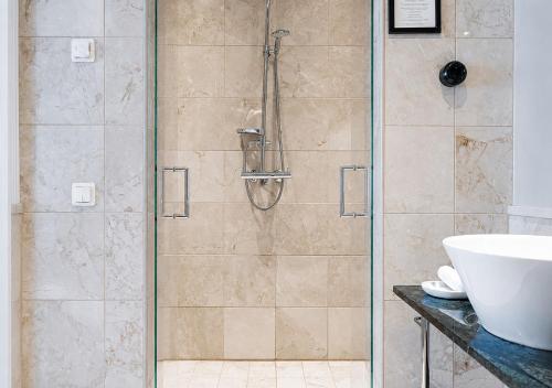 a bathroom with a shower with a sink at Elite Plaza Hotel Malmö in Malmö