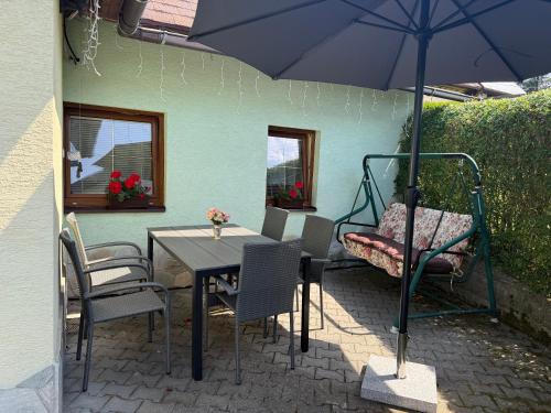 a patio with a table and chairs and an umbrella at Chatka Hanka in Terchová