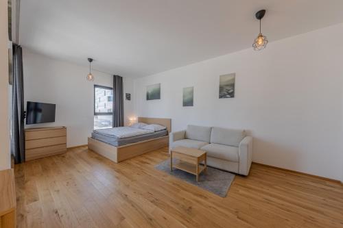 a living room with a couch and a tv at Island Safehouse in Olomouc