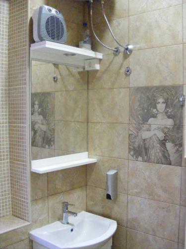 a bathroom with a sink and a shower with a mirror at Valor Central Apartments in Skopje
