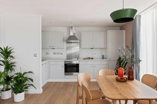 a kitchen with white cabinets and a wooden table at Cove Paradise Street in Liverpool