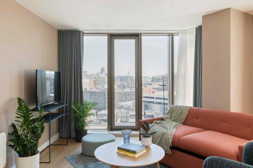 a living room with a couch and a large window at Cove Paradise Street in Liverpool