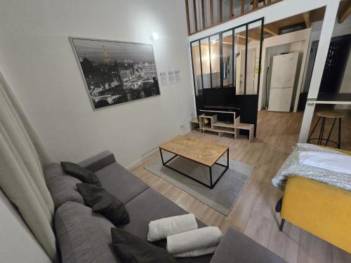 a living room with a couch and a table at La mezzanine Rouennaise in Rouen