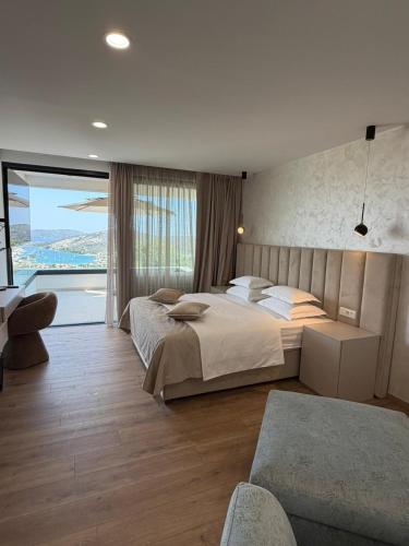 a bedroom with a large bed and a large window at View Villas Collection in Vinišće