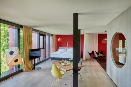 a bedroom with a bed and a room with a table at Studios & Spa Suites Rigiblick in Zurich