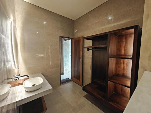 a bathroom with a sink and a mirror at Nawang Sakti in Ubud