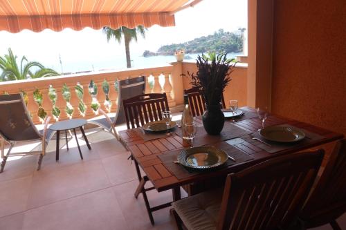 a dining room table and chairs with a view of the ocean at Plage de Miramar in Théoule-sur-Mer