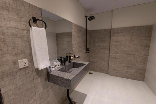 a bathroom with a sink and a shower at The Address Boutique Hotel Karachi in Karachi