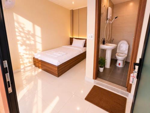 a small bathroom with a bed and a toilet at Lucky Hostel in Vientiane