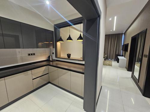 a kitchen with black and white cabinets and a window at Basra Platinum Hotel in Al Başrah