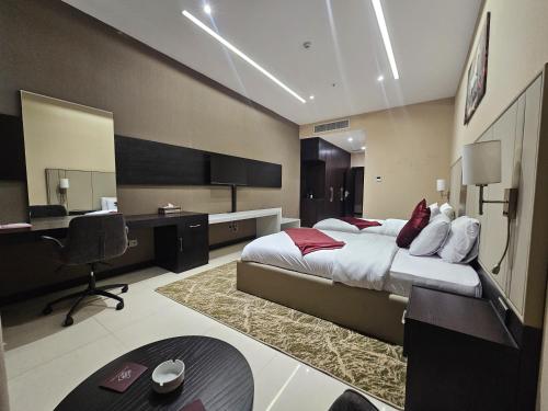 a bedroom with a large bed and a desk and a desk at Basra Platinum Hotel in Al Başrah