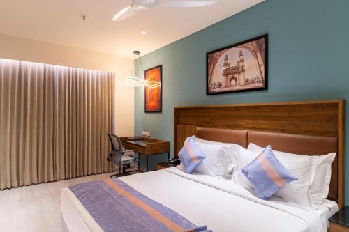 a bedroom with a bed and a desk with a chair at Lords Inn Sanand in Chharodi