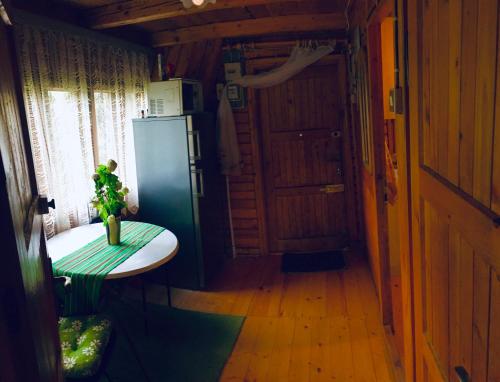a kitchen with a refrigerator and a table in a room at Leśny Zakątek Nowy Wiśnicz in Nowy Wiśnicz