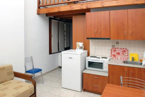 a kitchen with a white refrigerator and a microwave at Zouzoula House in Milina