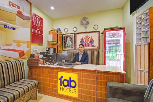 a woman sitting at a counter in a hotel room at FabHotel Prime Nakshatra Inn in Hyderabad